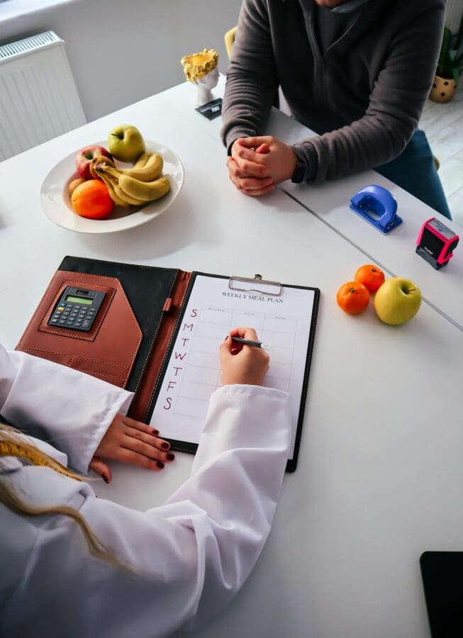 dietitian vs nutritionist professional at desk with client